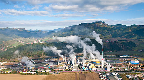 aerial view of a Mondi production site in a mountainous setting with blue, cloudy skies